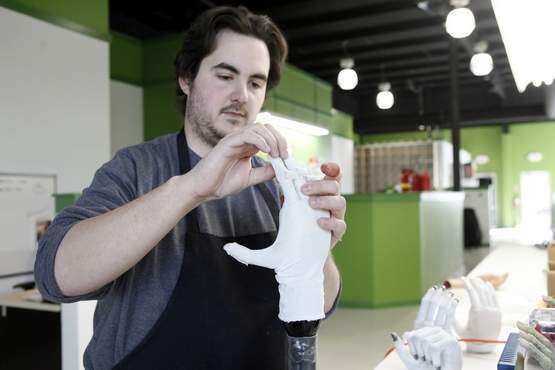 Chris Caron of New Paltz secures padding to the finger joints of a protective glove over an i-Limb prosthetic hand at Touch Bionics in Newburgh. 